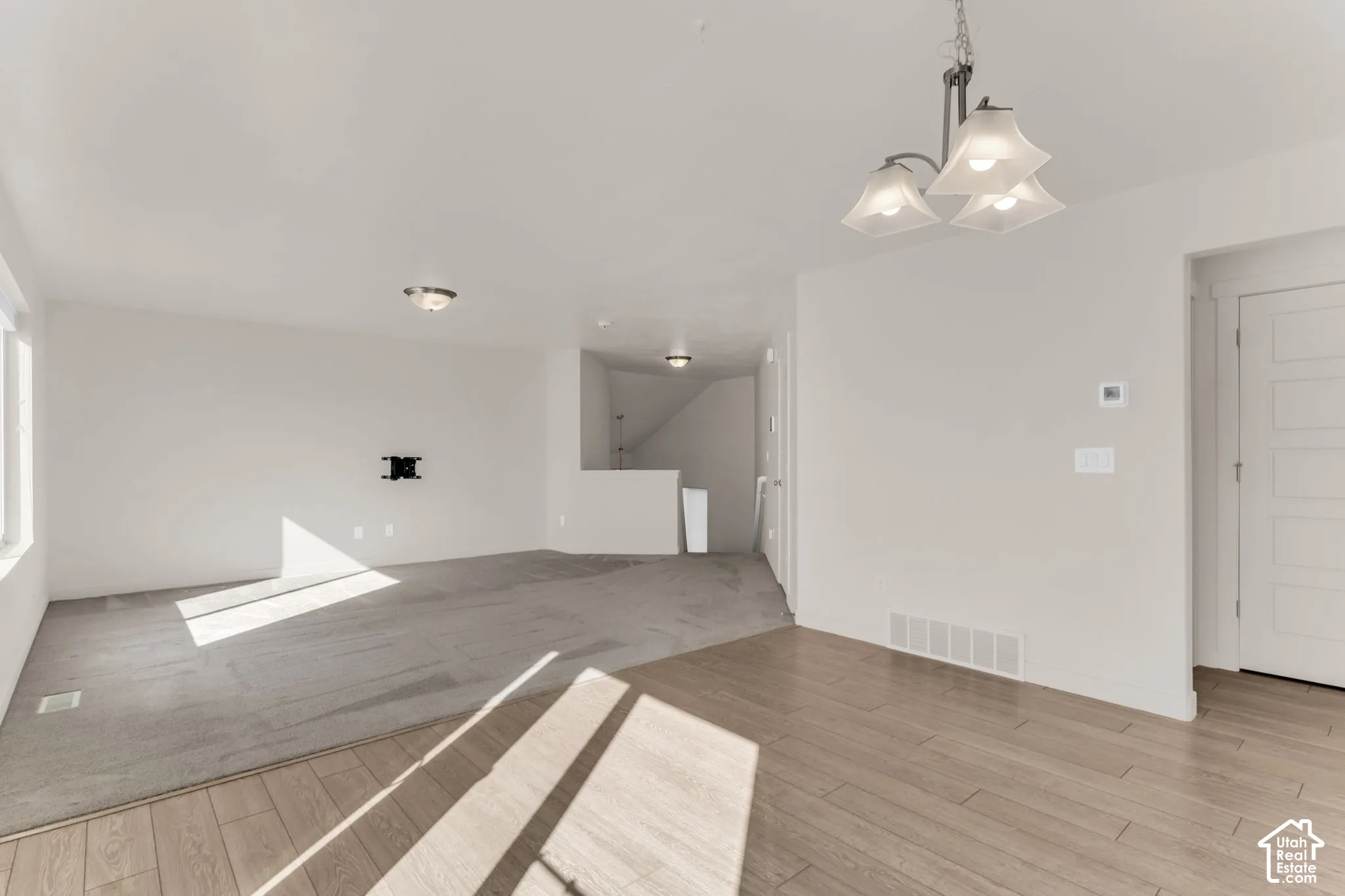 Neutral color palette, wood-look flooring, recessed lighting, ceiling-mounted light fixture, white interior doors