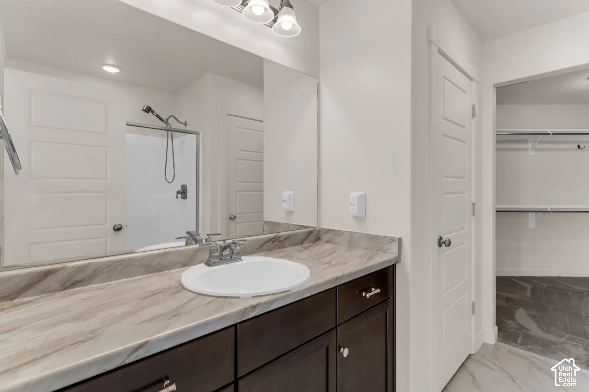 Owner's Suite - Vanity with integrated sink, expansive countertop, and dark wood-finish cabinetry