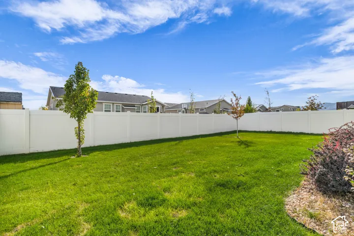 Expansive lawn area with a white privacy fence