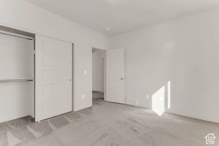 Light gray wall-to-wall carpeting, white interior walls, and a white interior door