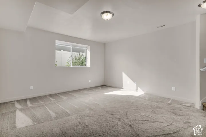 Carpeted flooring, recessed lighting, and a window with a white frame
