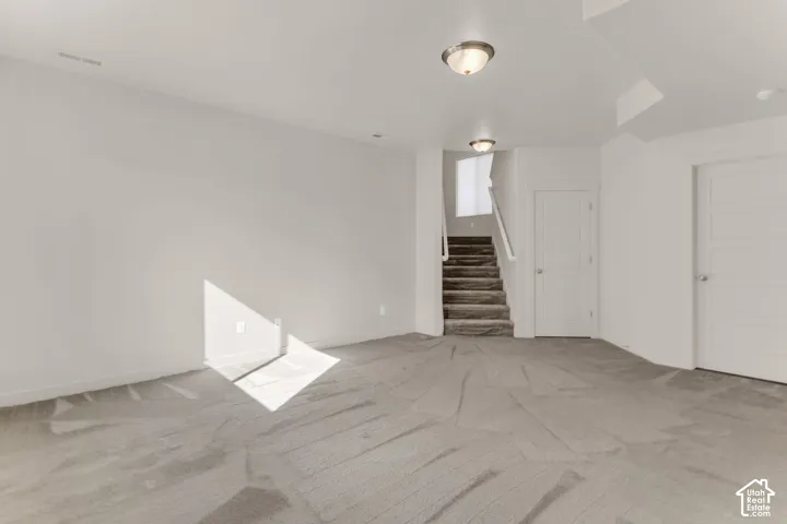 Spacious room featuring neutral carpeting and light-colored walls