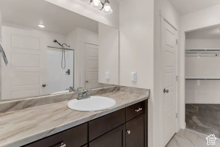 Owner's Suite - Vanity with integrated sink, expansive countertop, and dark wood-finish cabinetry