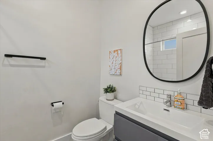 Modern vanity with integrated sink, subway tile backsplash, and a large black-framed mirror