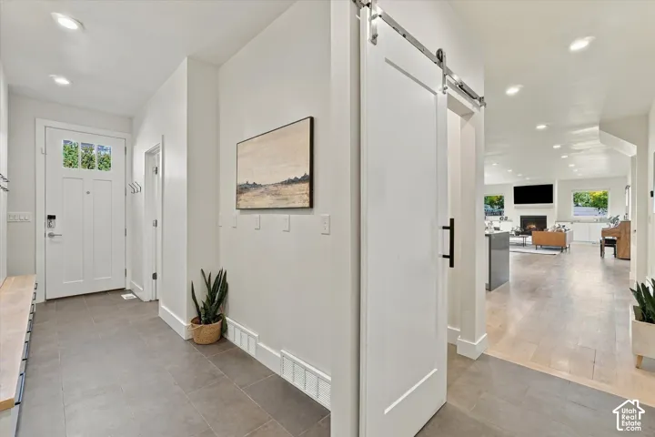 Entryway featuring tile flooring, recessed lighting, and a barn door with matte black hardware