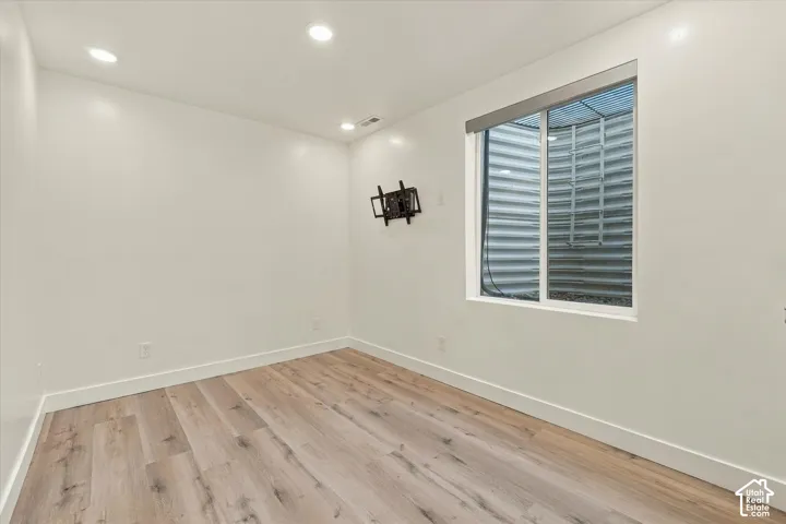 Recessed lighting, wood-finish flooring, and a white window frame