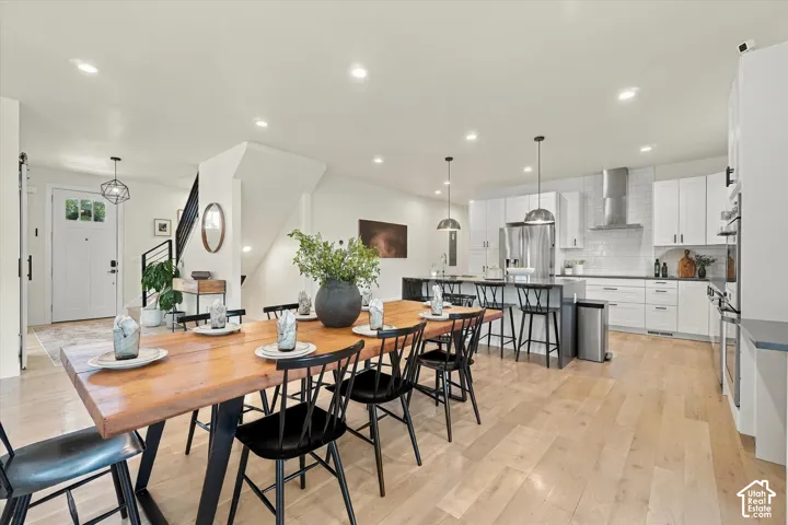Open-concept living space featuring wood-finish flooring, recessed lighting, and a modern kitchen with a large island