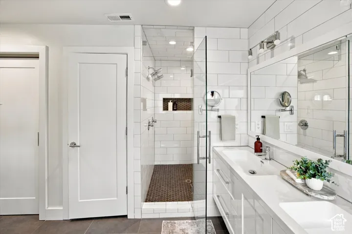 Spa-inspired primary bathroom showcasing a walk-in shower with subway tile surround, frameless glass enclosure, and integrated niche storage