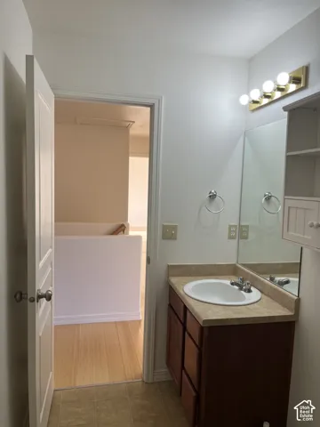 Vanity with integrated sink, laminate countertop, and wood-finish cabinetry