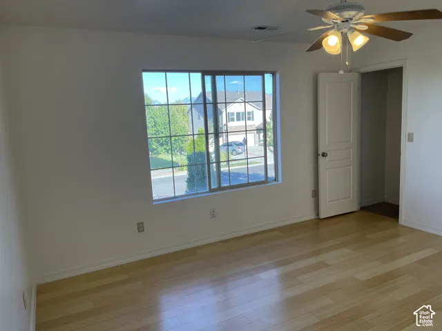 Wood-finish flooring, white walls, and a window with grid detailing