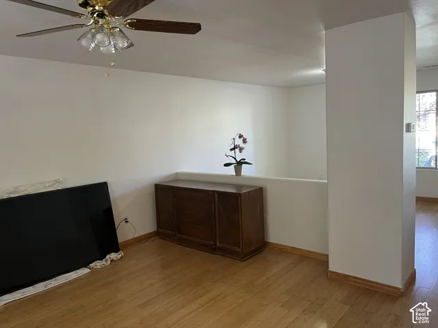 Wood-finish flooring throughout, with a ceiling fan light fixture and a half-wall partition