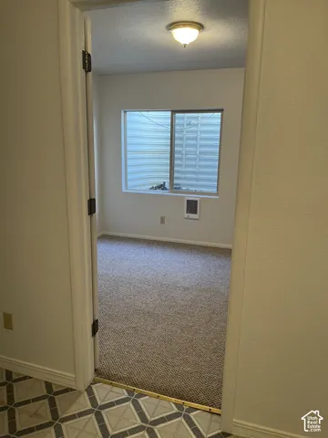 Recessed window with white trim, wall-mounted air register, and neutral tone carpeting