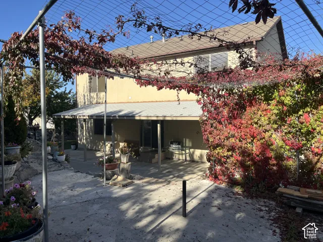 Concrete patio with an attached covered awning and vibrant autumnal foliage