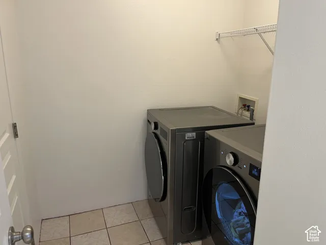 Laundry area featuring tile flooring, a utility hookup, and a wall-mounted wire shelf