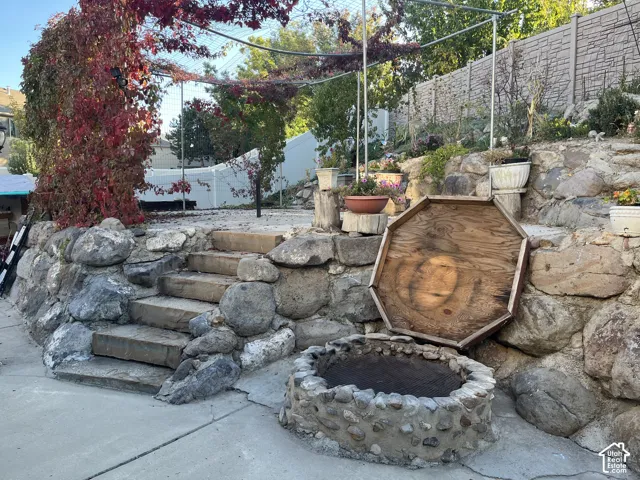 Stone retaining wall featuring integrated steps and a built-in fire pit