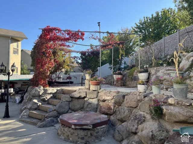 Tiered backyard hardscaping featuring natural stone and concrete steps