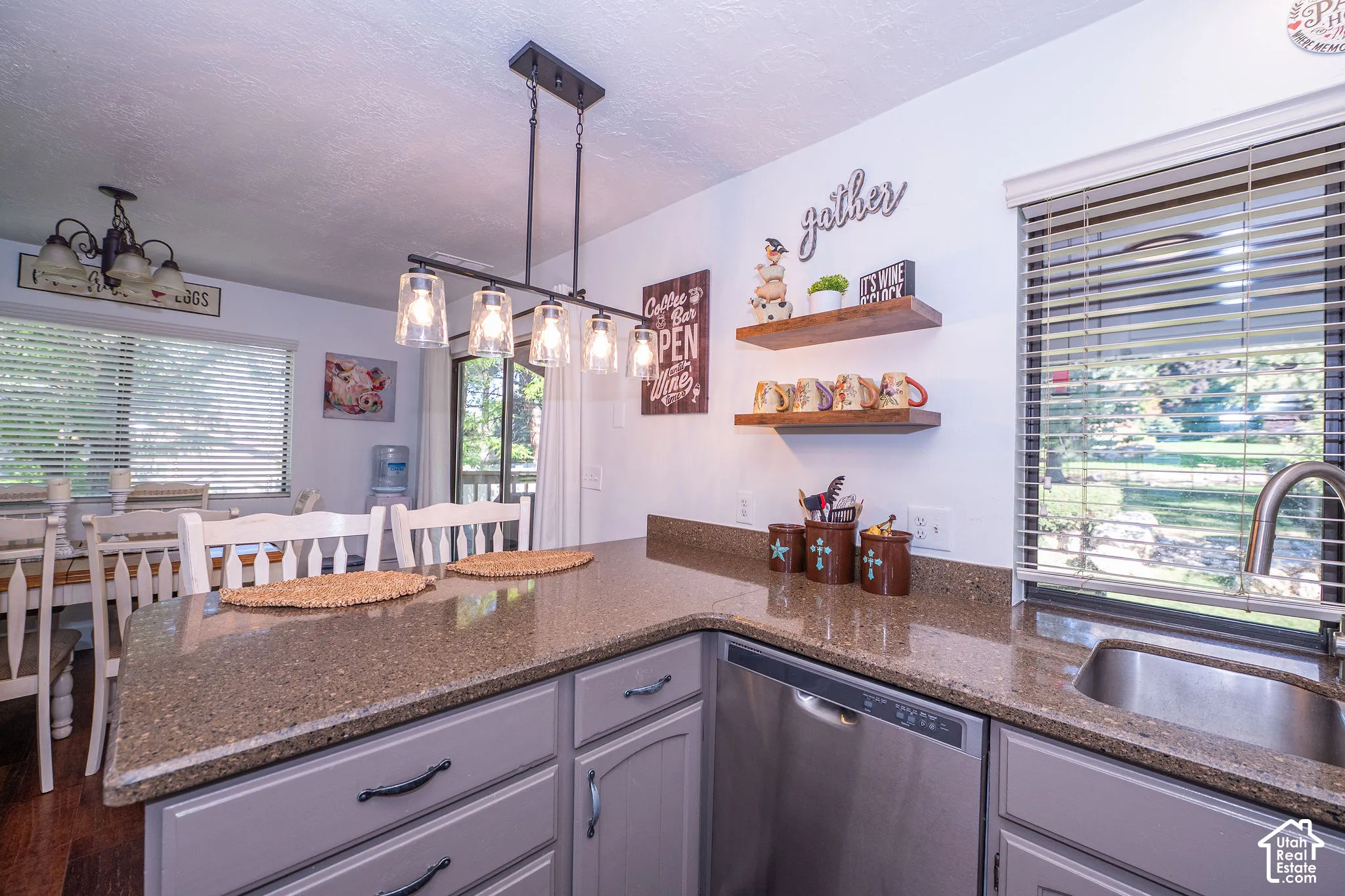 kitchen granite counter with a stainless-steel sink, coordinating dishwasher, and light cabinetry