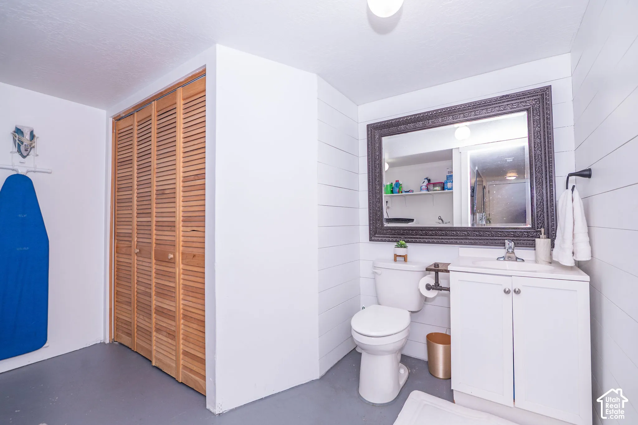 White vanity with dual cabinet doors, chrome faucet, and integrated sink