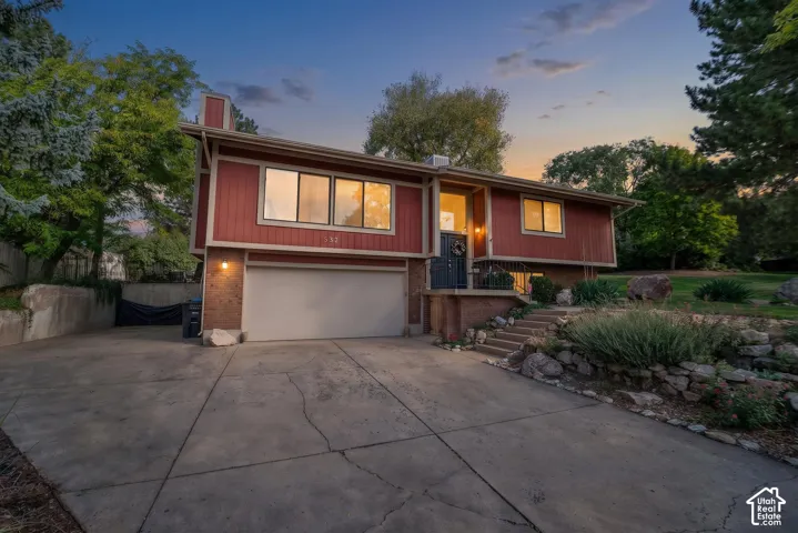 Split-level exterior featuring red siding and brick accents