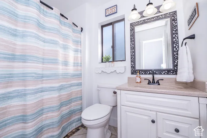 Guest bathroom with a white vanity with a neutral-toned countertop and an ornate framed mirror, complemented by a black wall-mounted faucet