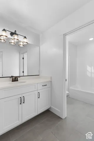 White shaker-style vanity with a single basin sink, white countertop, and dark bronze faucet