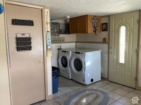 Laundry area featuring upper cabinetry, a utility sink, and tile flooring