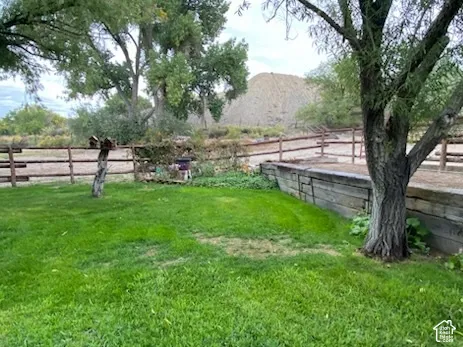 Grassed yard area, mature trees, and a wood-post fence