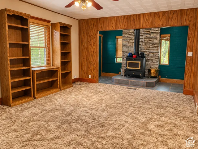 Wood-paneled walls and ceiling fan with integrated lighting