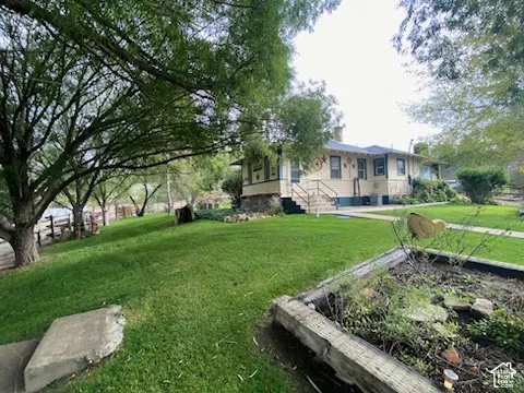 Manicured lawn with mature trees and a raised garden bed