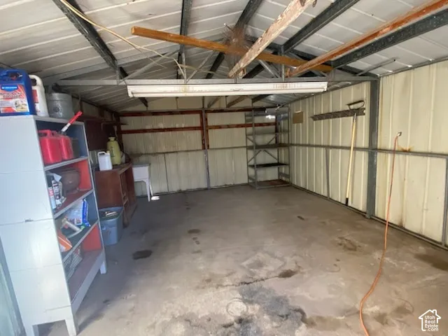 Concrete floor, metal-paneled walls, exposed ceiling beams, built-in shelving