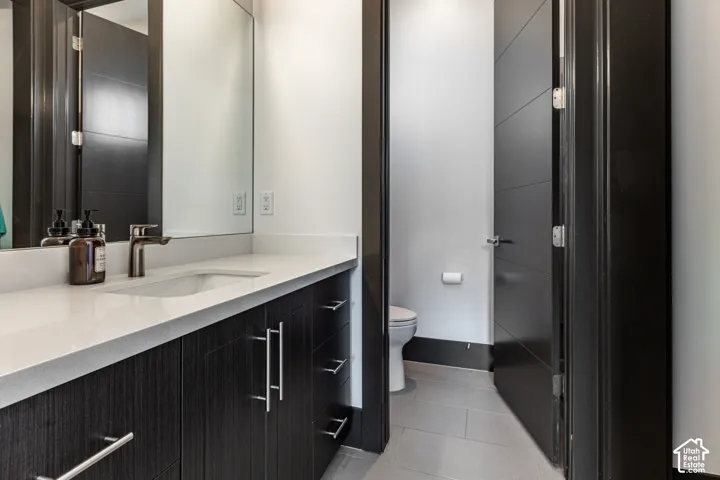 Vanity with a light-colored countertop, integrated sink, and dark wood-finish cabinetry