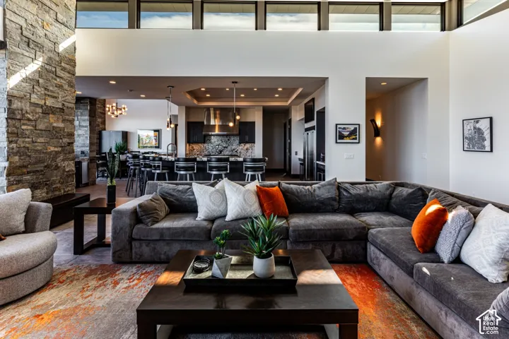 Vaulted ceilings with clerestory windows, stone accent wall, recessed lighting, and a kitchen featuring a large island with bar seating and stainless steel appliances