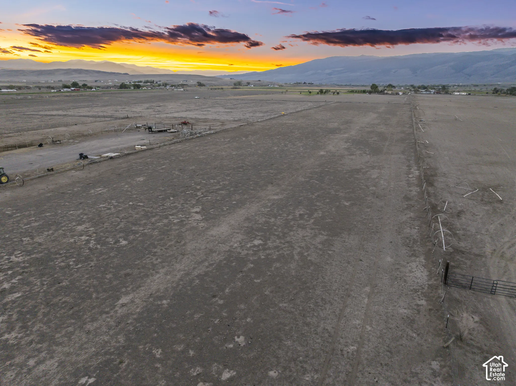 Expansive open acreage featuring a perimeter fence and metal gate