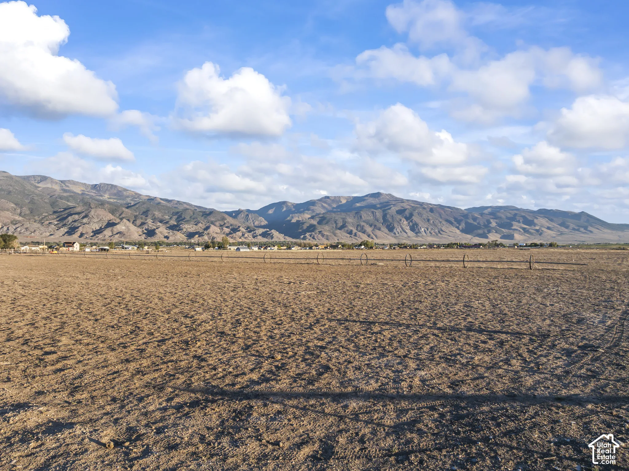Expansive open land with distant mountain ranges and a clear sky