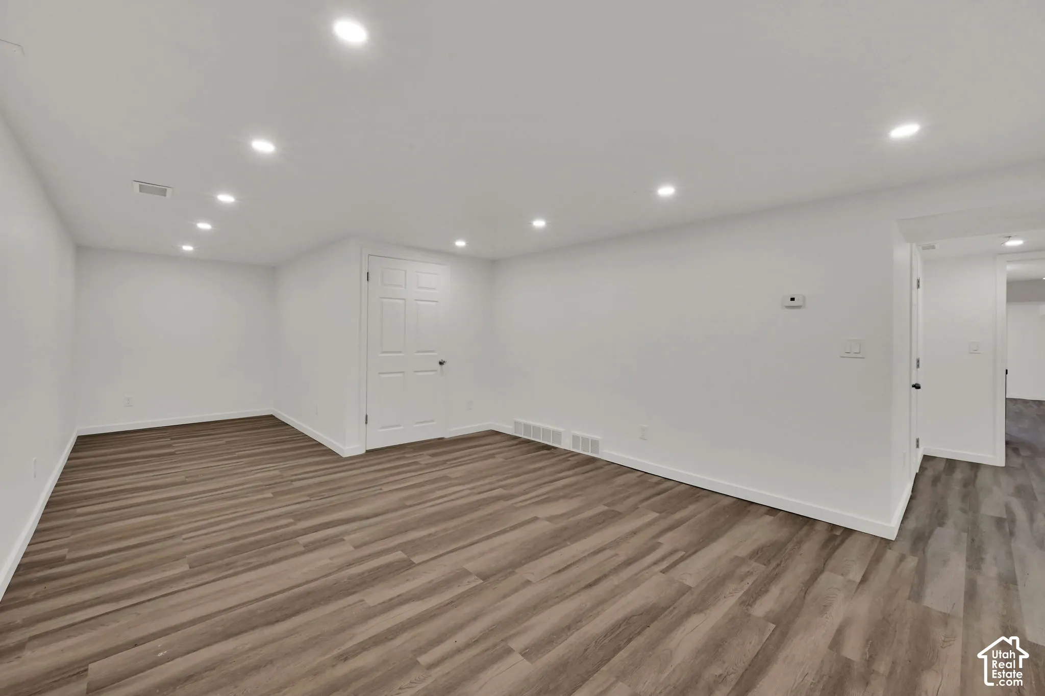 Recessed lighting, light wood-finish flooring, white walls, and white trim