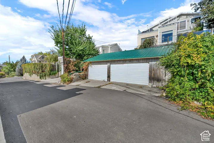 Two-car garage with green metal roofing and white overhead doors