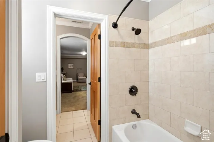 Tiled tub and shower combination with bronze fixtures and a decorative accent band