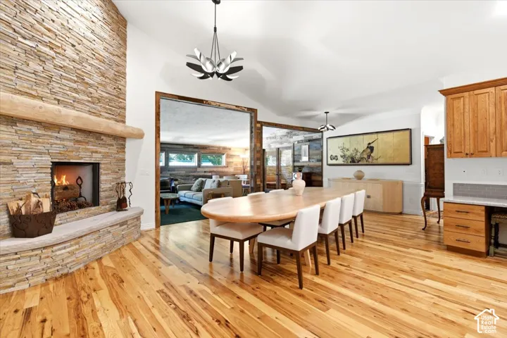 Stacked stone fireplace with a stone hearth, wood-finish flooring, and built-in cabinetry