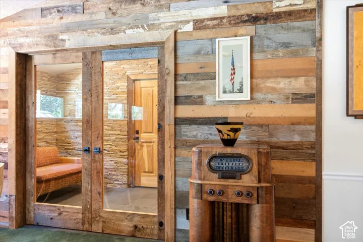 Reclaimed wood plank wall with natural wood French doors and black hardware