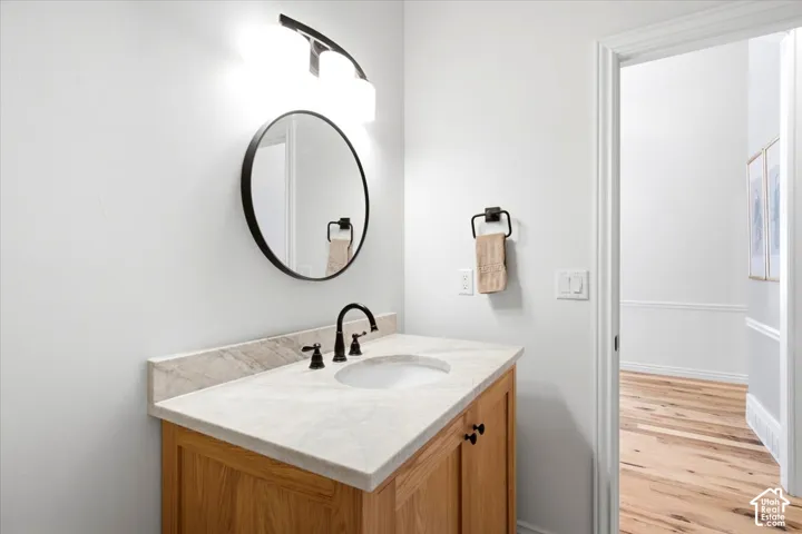 Wood-finish vanity with a stone countertop and an undermount sink