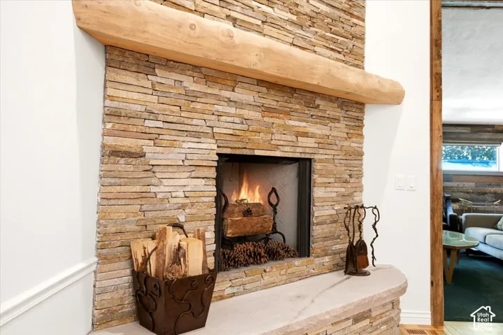 Stone-clad fireplace with a natural wood mantel