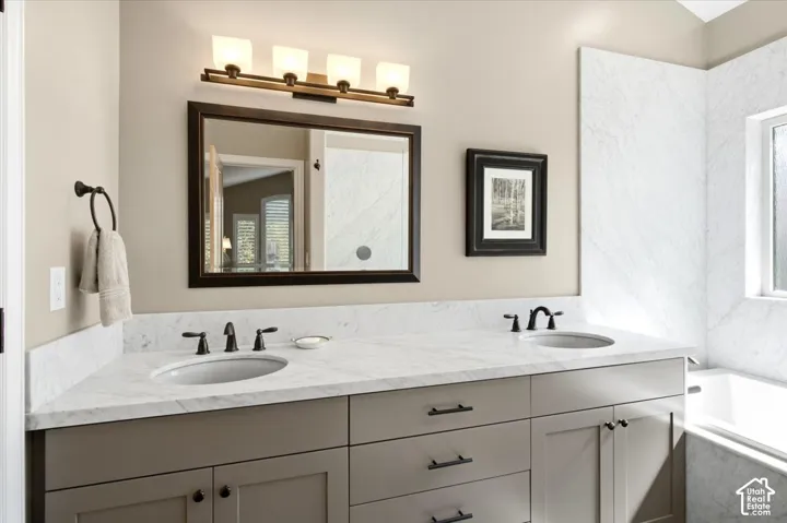 Double vanity with undermount sinks, stone countertops, and matte black hardware