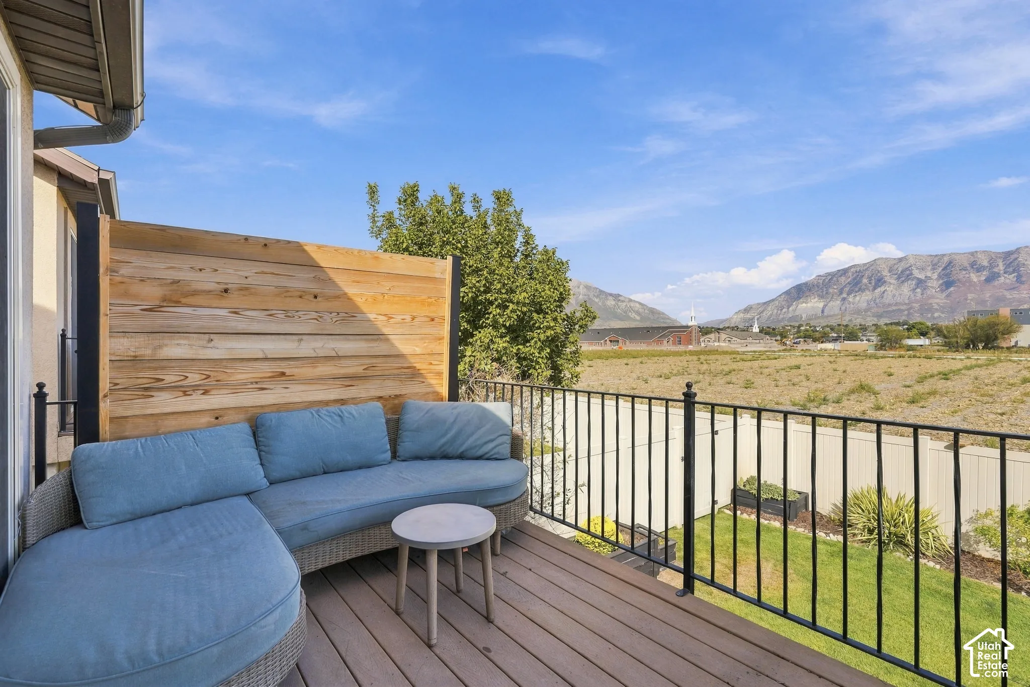 Outdoor deck featuring wood-finish flooring, a privacy screen, and black metal railings with mountain view of mount Timpanogos.