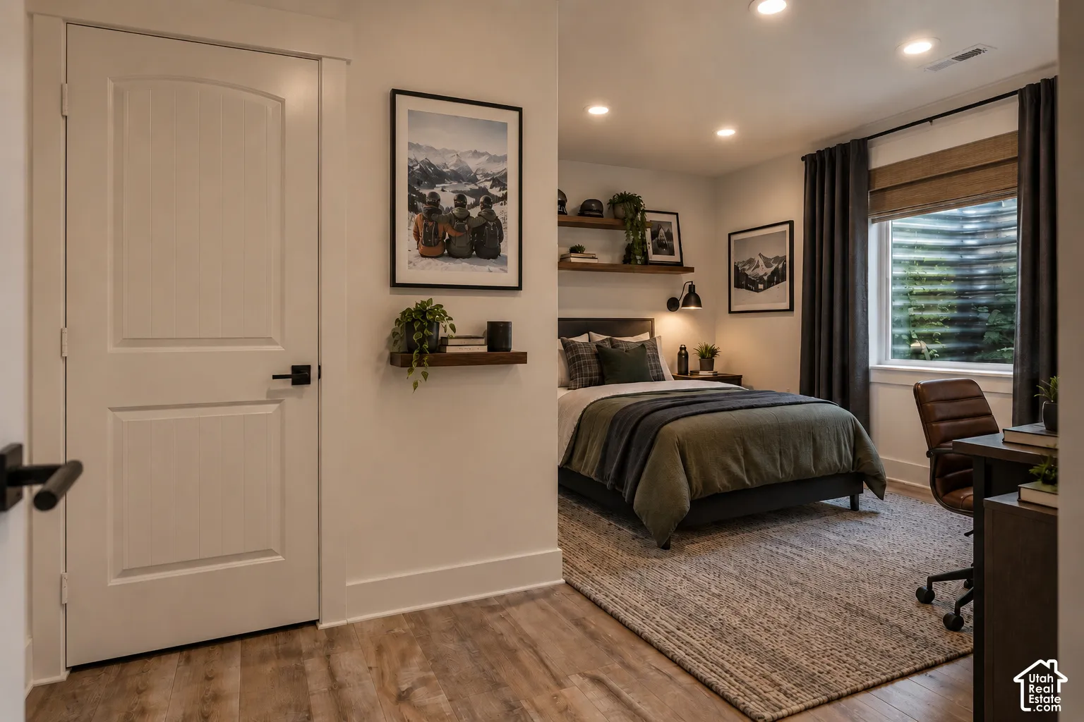 Bedroom # 5 Recessed lighting, wood-finish flooring, white paneled door with matte black hardware, built-in shelving, and a window with a woven shade