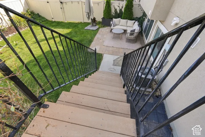 Composite Deck and Backyard OasisDescend the sturdy black metal railing staircase to discover a multi-level outdoor living space