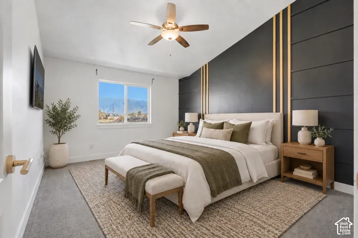 Vaulted ceilings featuring a central light-integrated ceiling fan and a dark-toned accent wall with vertical metallic trim