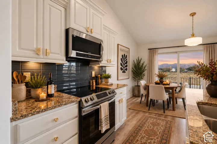 White shaker-style cabinetry with gold-toned hardware, stainless steel appliances, granite countertops, and a dark tile backsplash