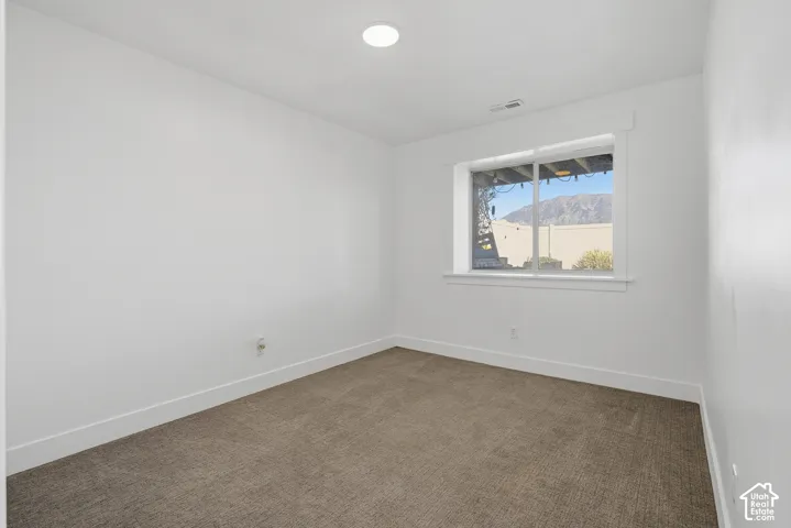 Recessed lighting, wall-to-wall carpeting, window with white trim, and white painted walls