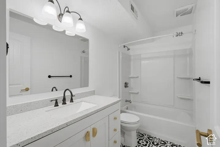 Vanity with a white countertop and integrated sink, bronze-finish faucet, and gold-tone hardware