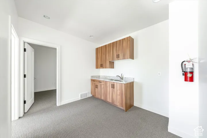 Built-in cabinetry with a sink, light-toned wood-finish cabinets, and a light-colored countertop